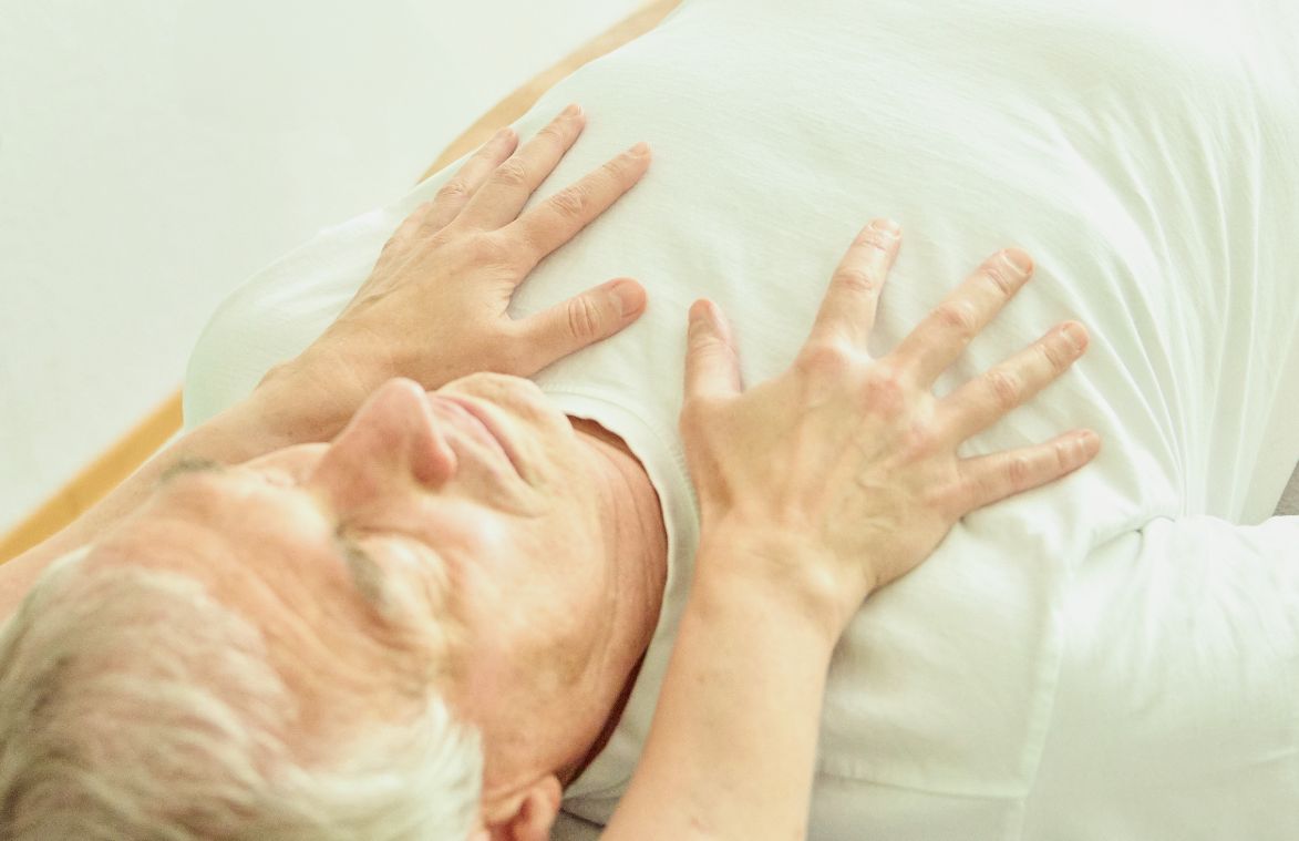 Hände auf dem Brustkob eines Seniors